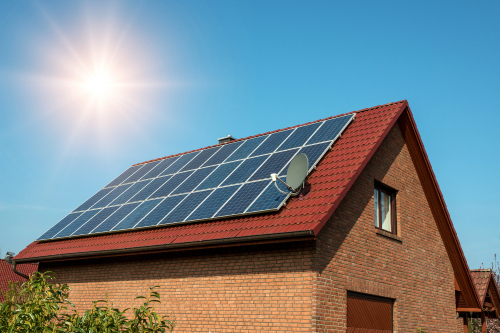 Solar panels installed on the roof of a house, showcasing renewable energy technology in a residential setting.