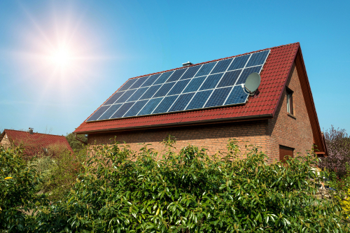 Solar panels on a residential roof, absorbing sunlight, representing eco-friendly energy generation.