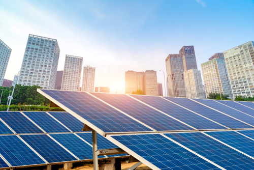 Solar panels positioned before a city skyline, highlighting the integration of green technology in urban environments.