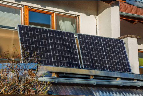 Solar panels installed on the balcony of a house, showcasing renewable energy technology in a residential setting.