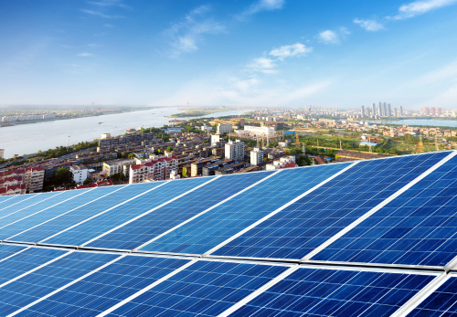 Solar panels installed on the roof of an urban building, showcasing renewable energy use in a city environment.